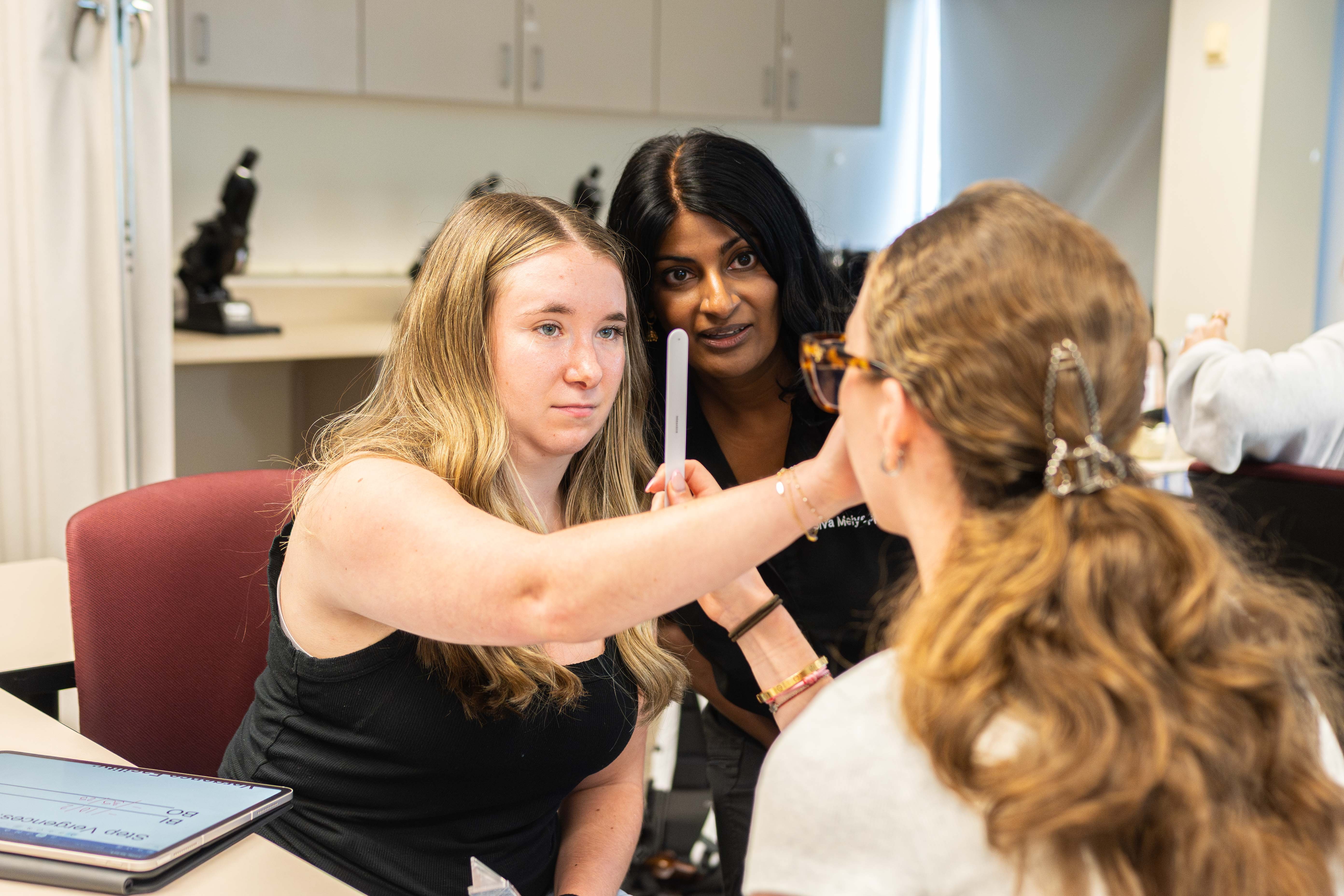 Student conducts eye exam on classmate in class