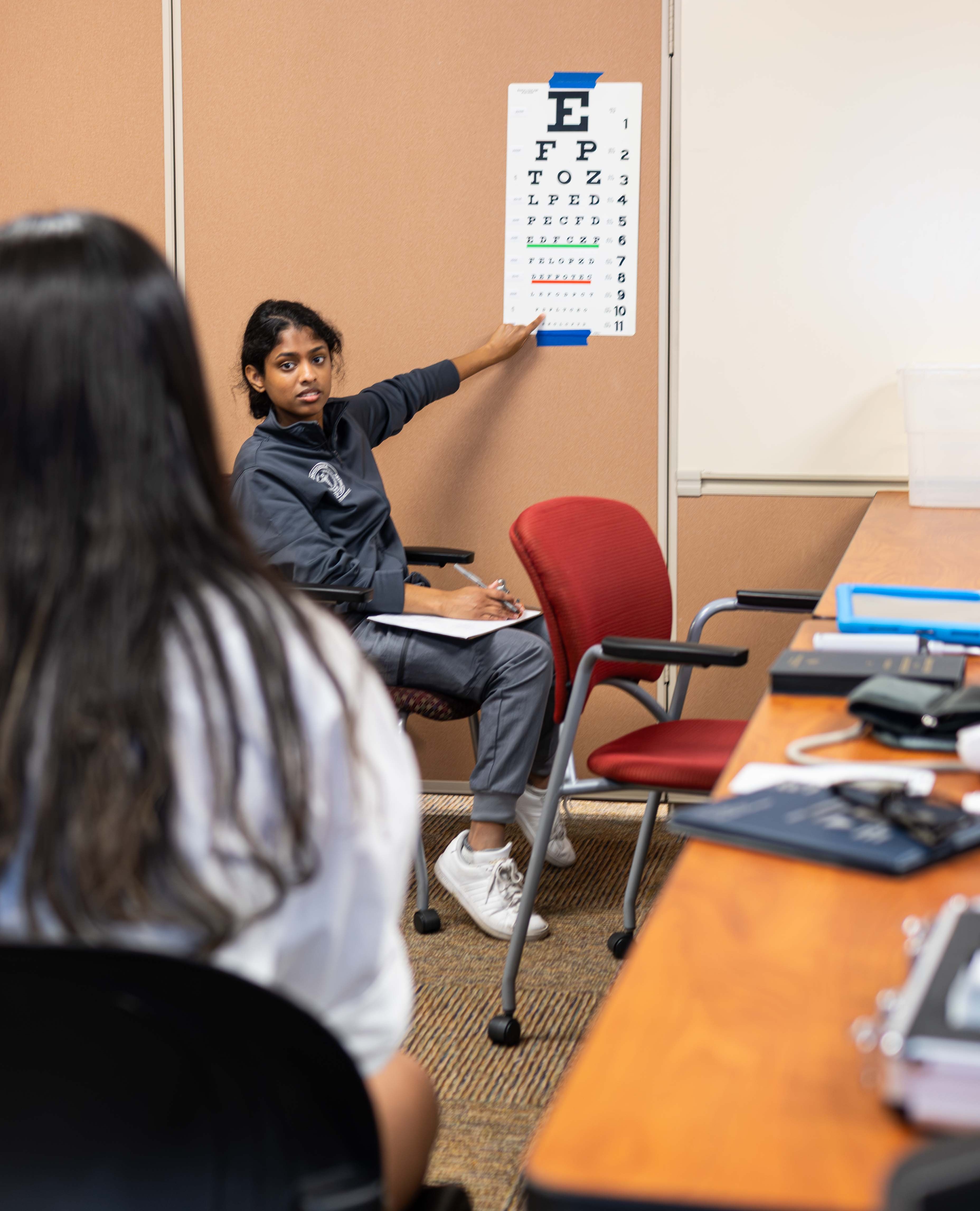 Student points to eye chart during exam