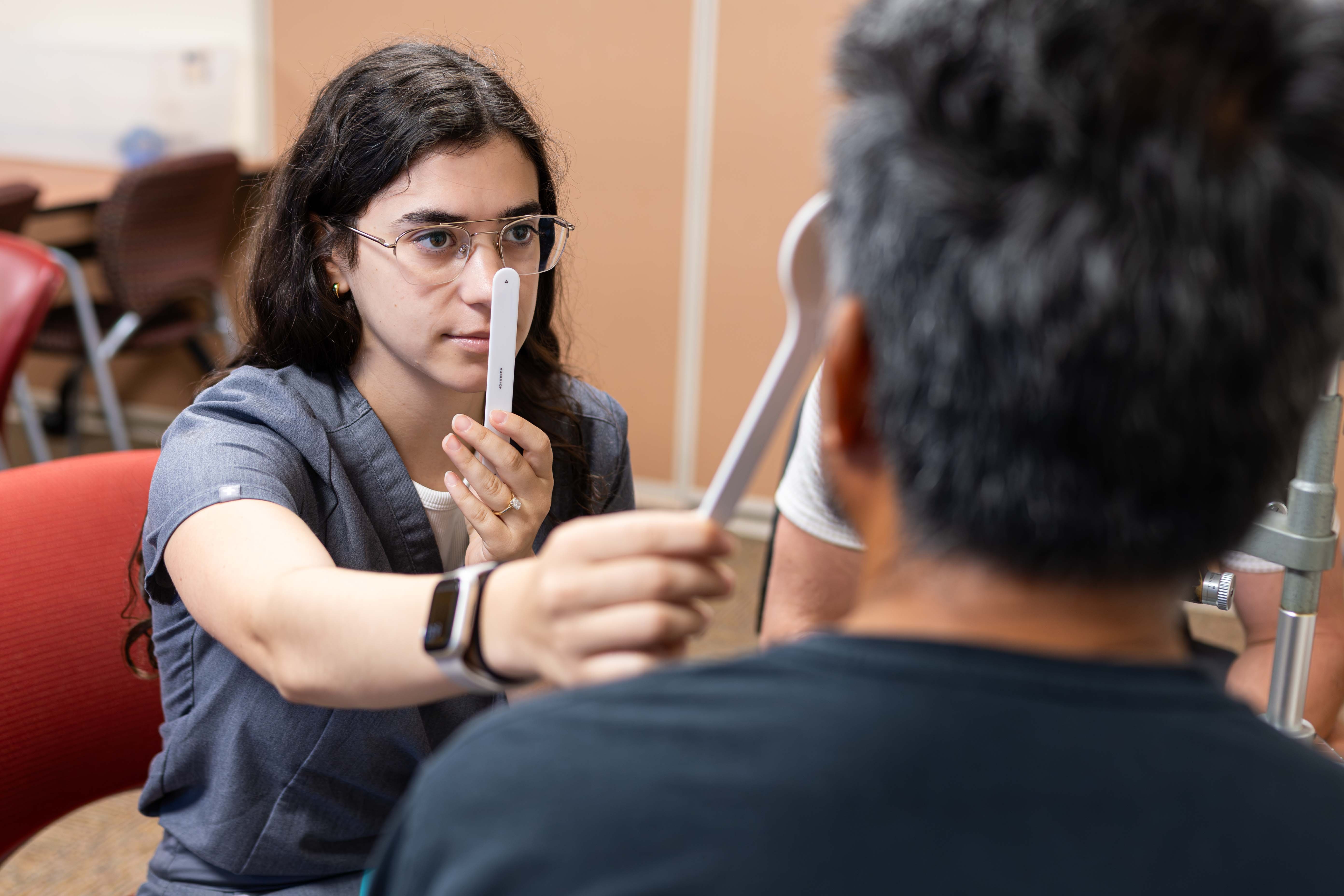 Student examines patient's eyes
