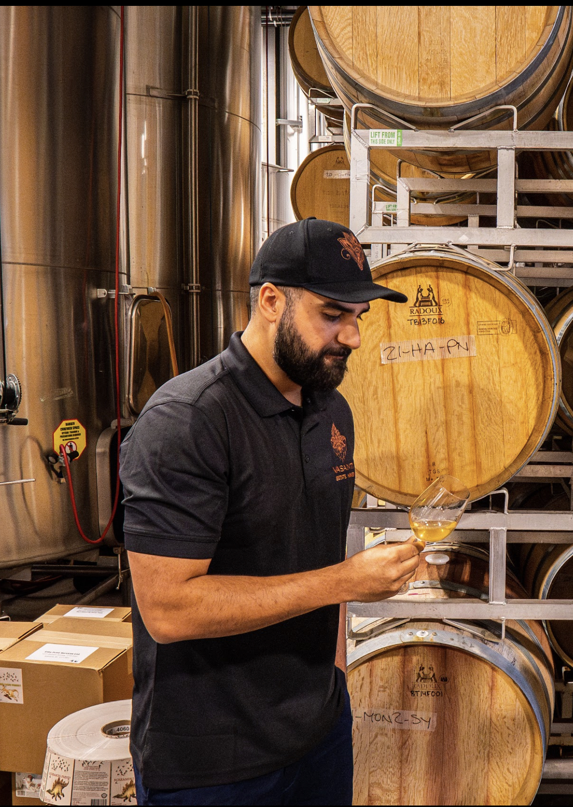 Dr. Sidhu inspects wine in the barrel room