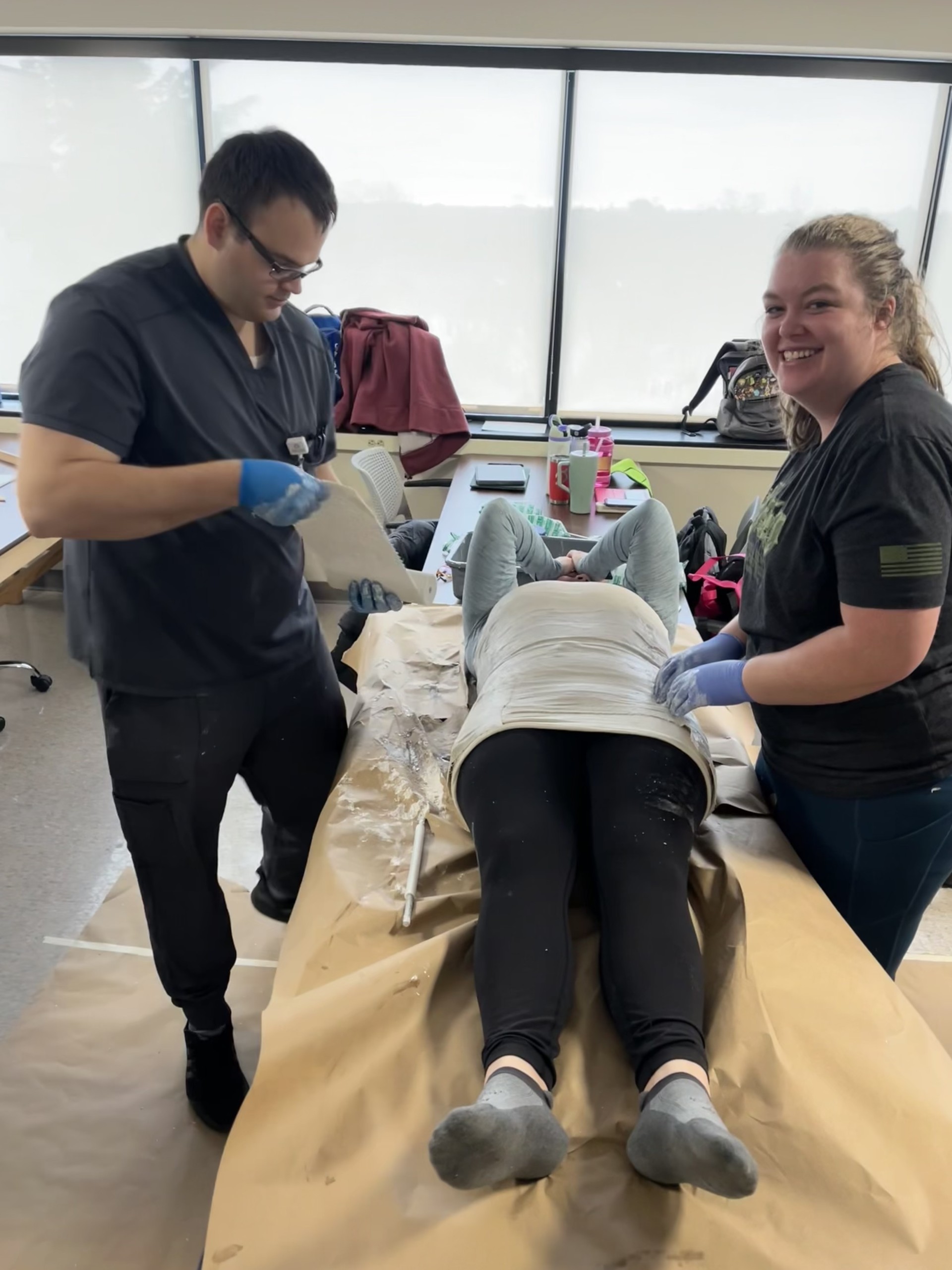 Logan Tonini and another student work on patient