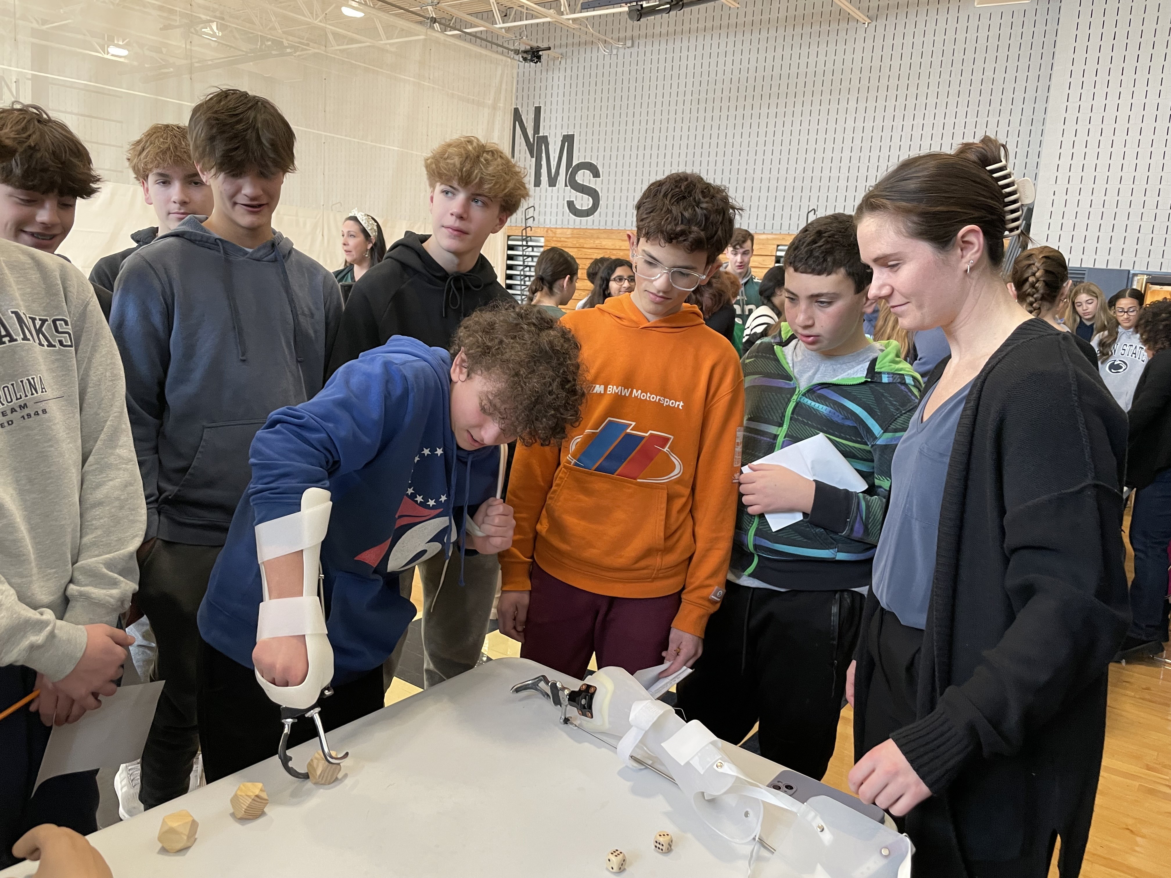 Students being shown how to use a prosthetic hand