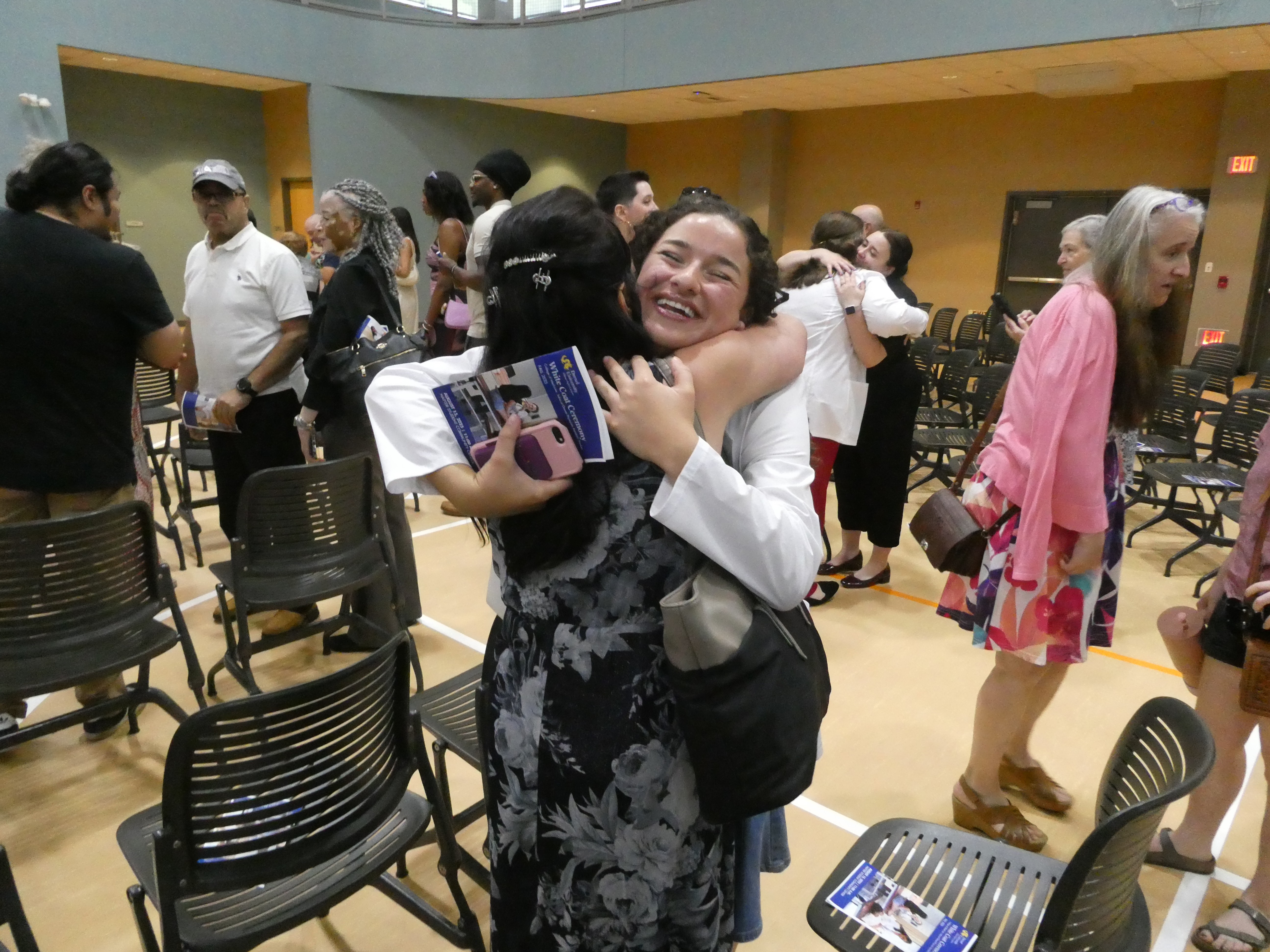 Nicole Gaspari hugs relative at white coat