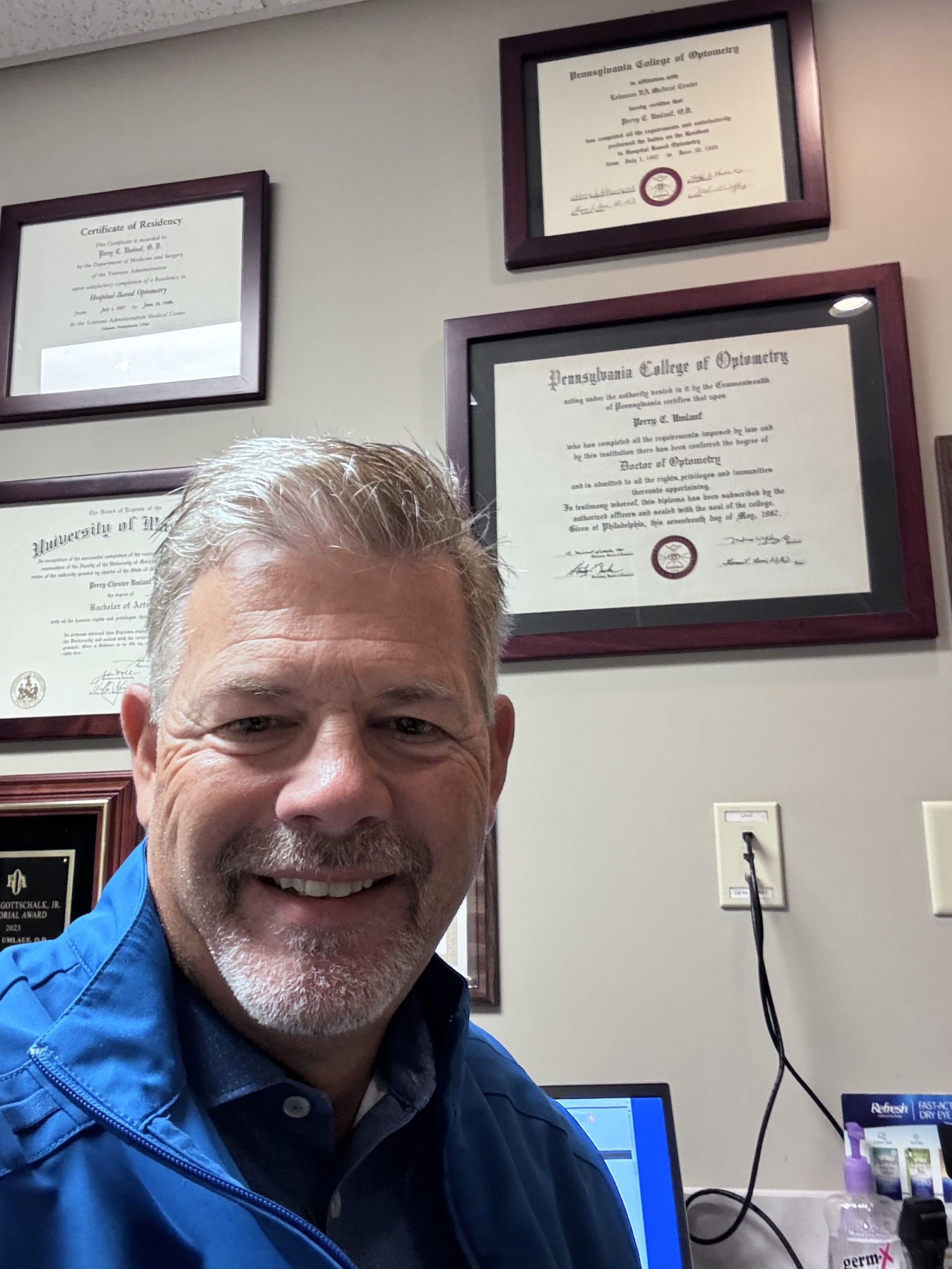 Dr. Perry Umlauf with his PCO diploma on the wall