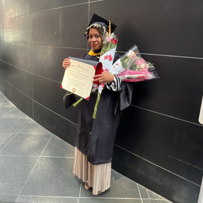 Sultana Abdur-Raheem at commencement holding her diploma