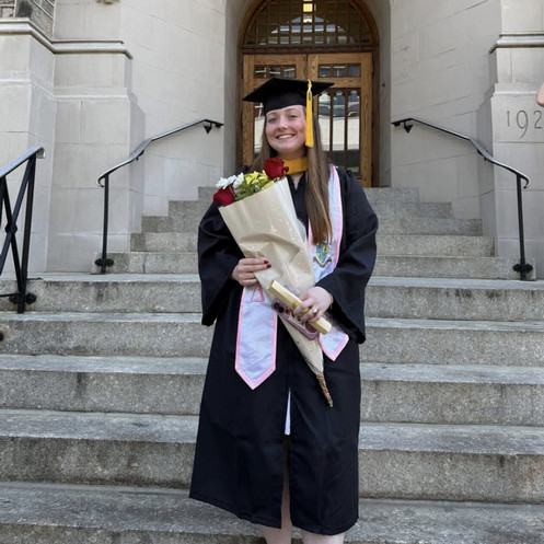Emma wearing her cap and gown while holding flowers