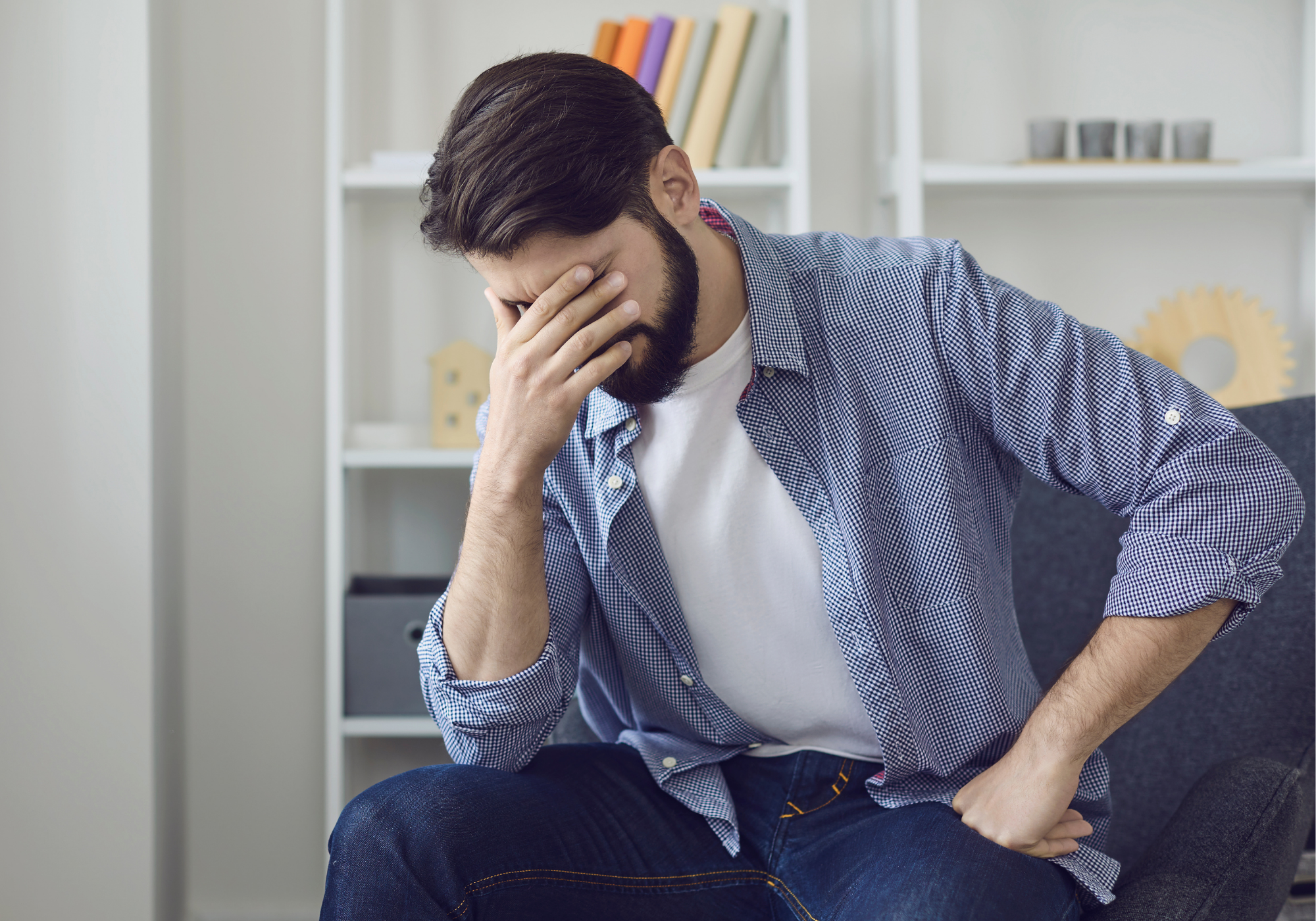 man with hand over his eyes