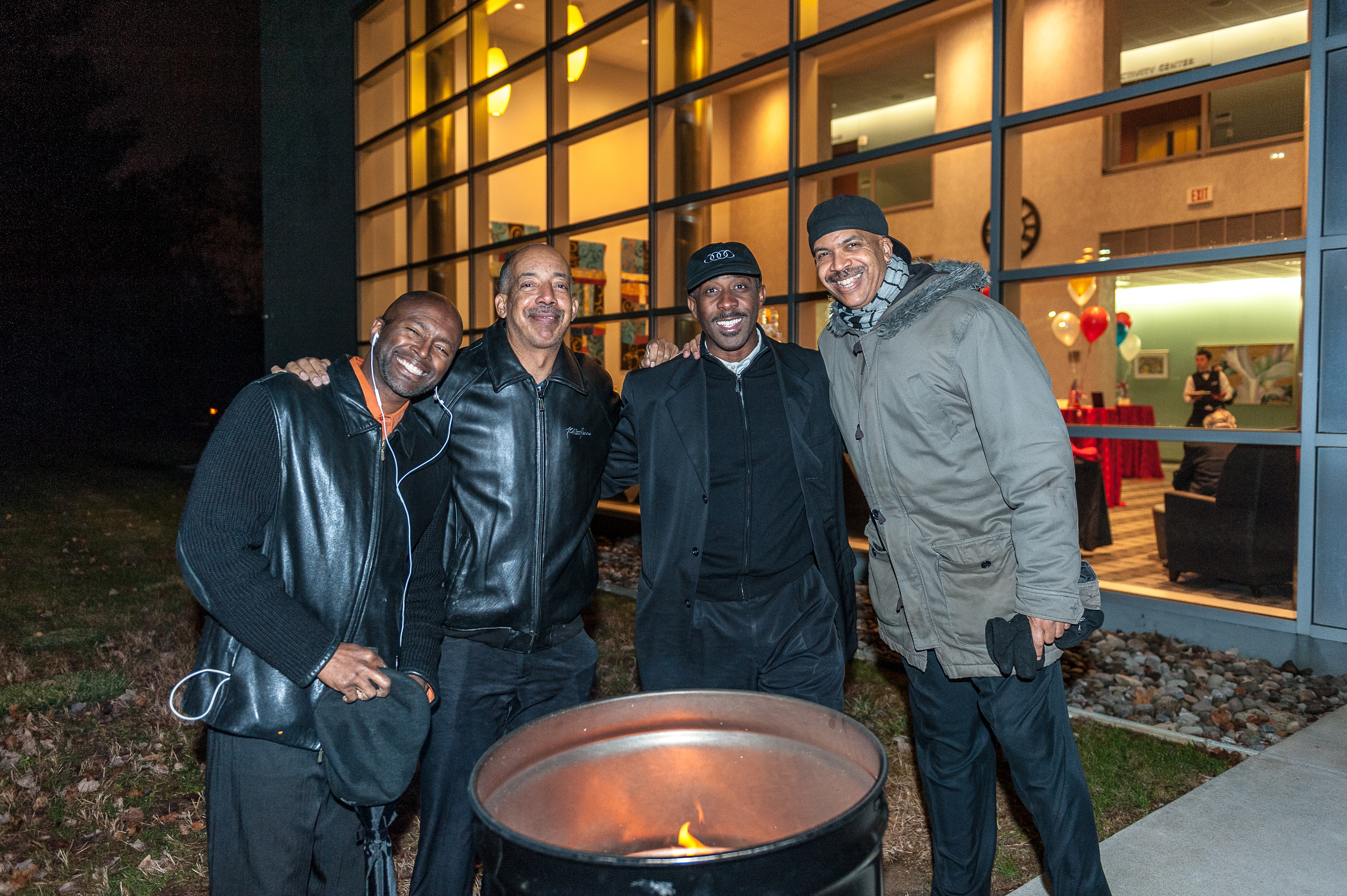group of men outside fire barrel