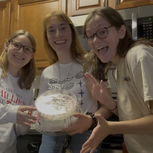 group photo of women holding a cake