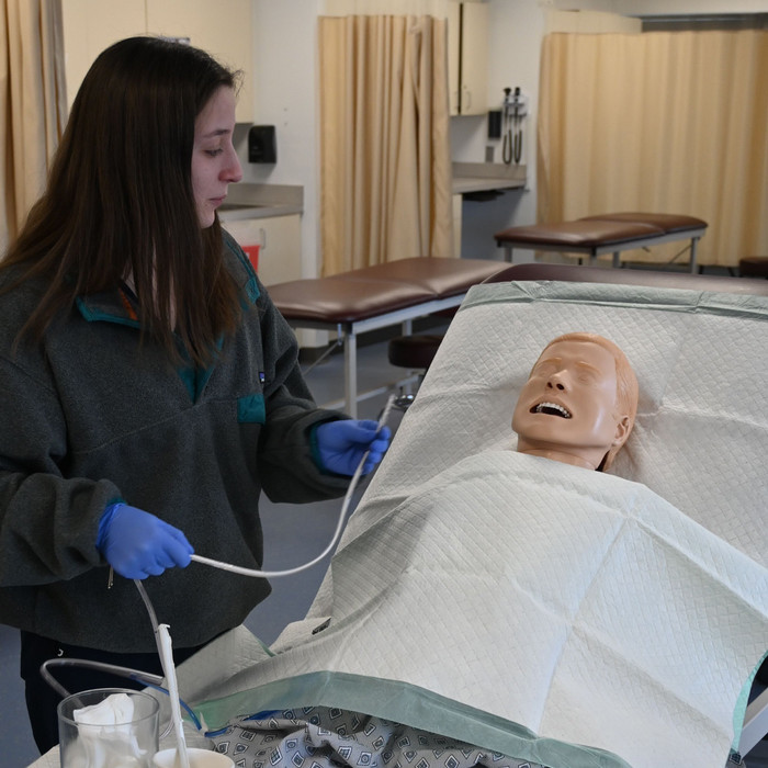 student practicing NG tube insertion on dummy