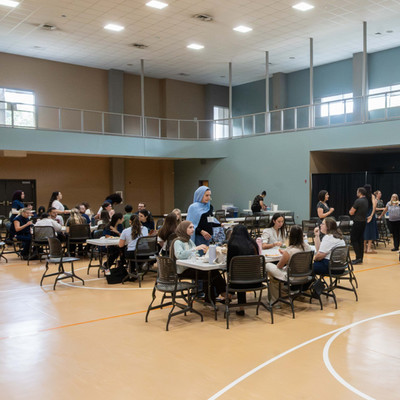 students sitting at tables in the gym