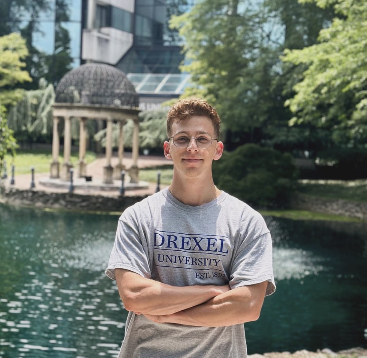 student wearing Drexel shirt standing in front of gazebo