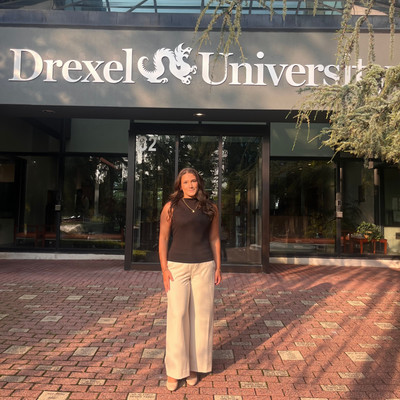 Corrina standing in front of the Drexel sign on campus
