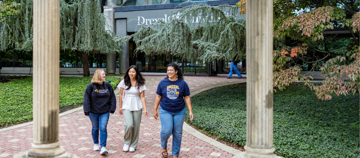 students walking in front of Drexel sign