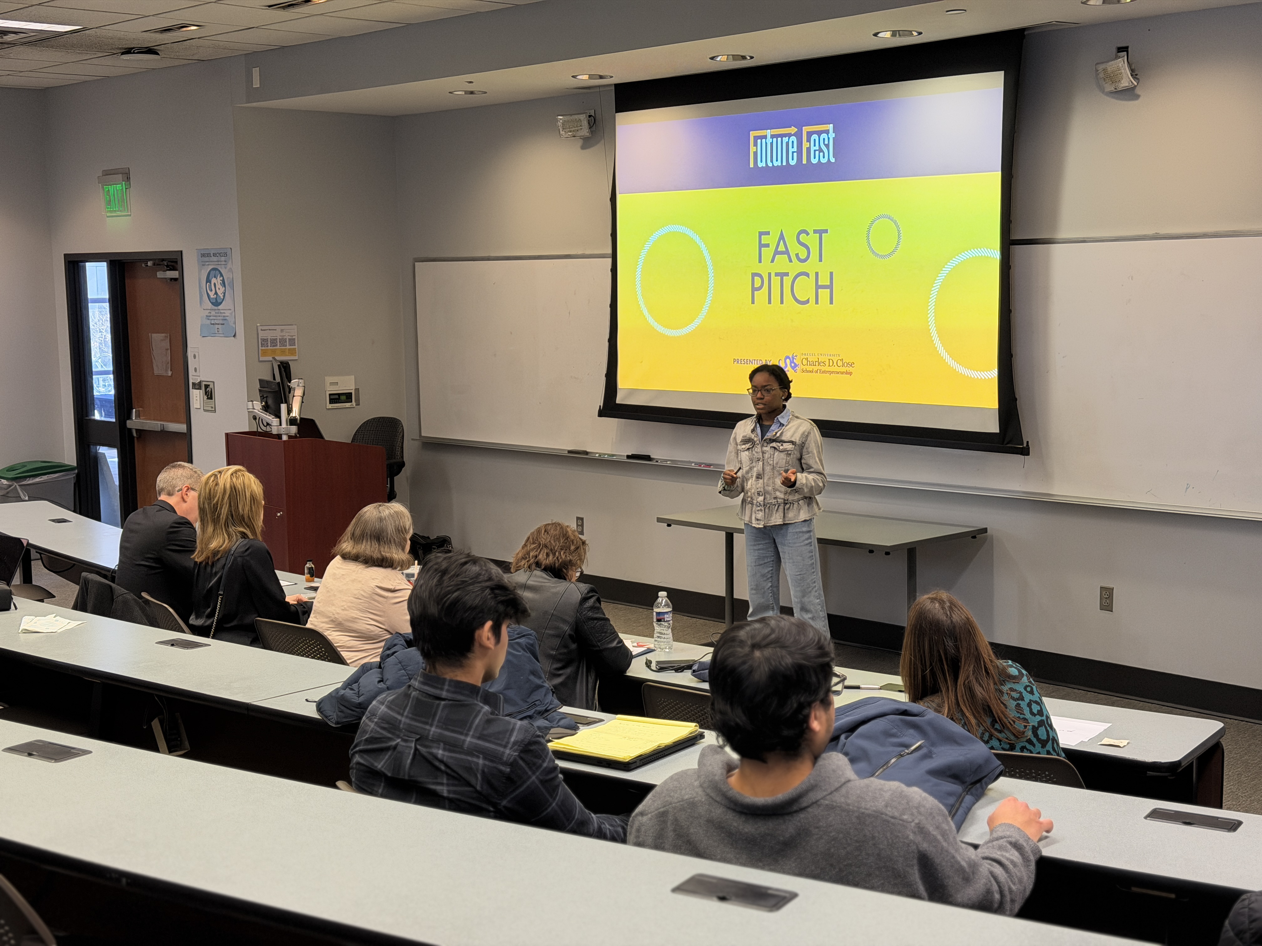 women pitching an idea to a room full of people