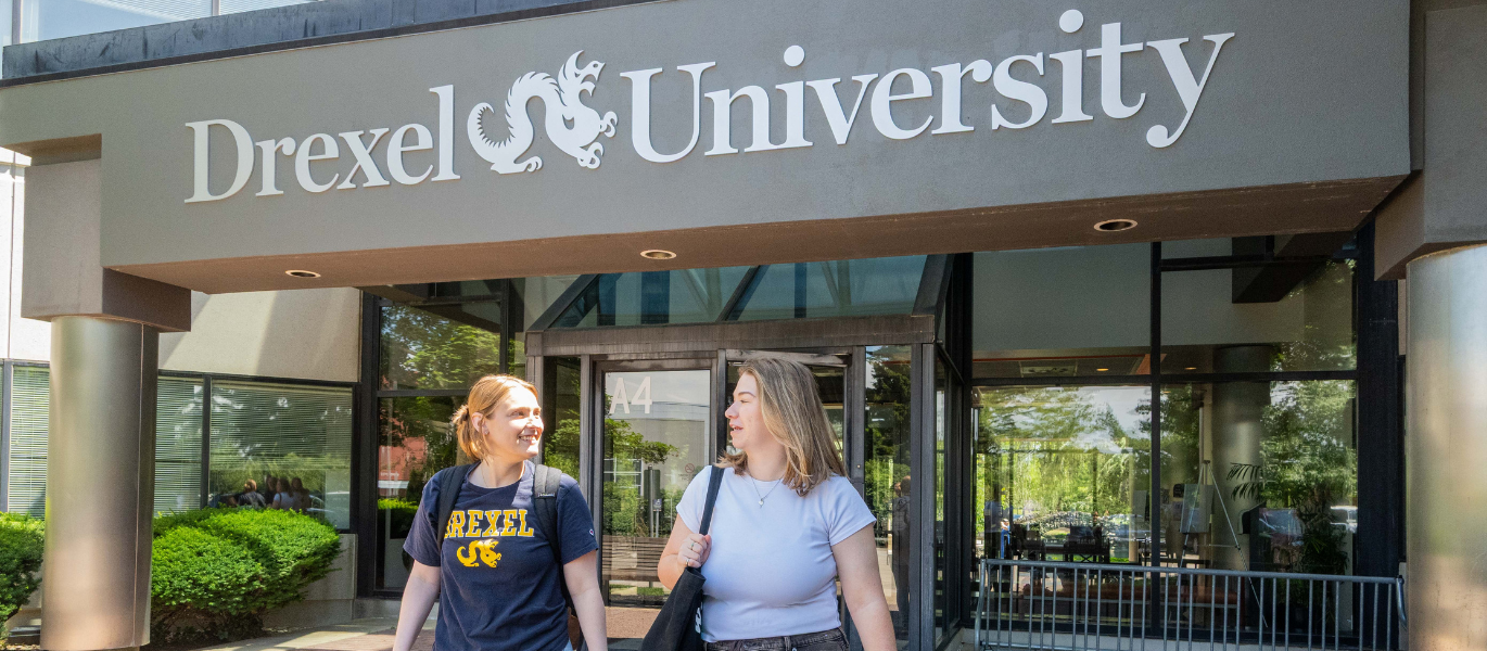 students walking out of campus building