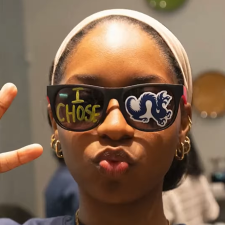 student making a kiss face and giving peace sign