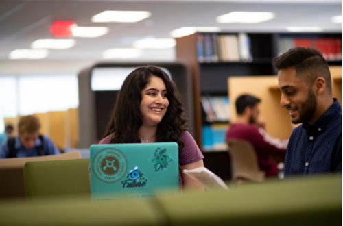 two students looking at a laptop