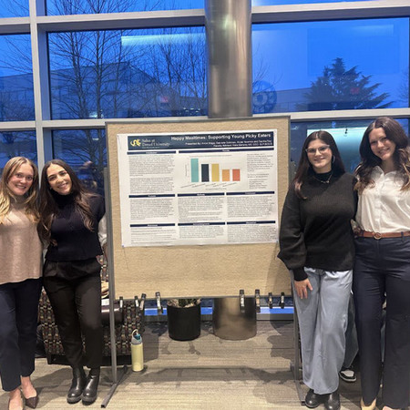 SLP students in front of capstone poster