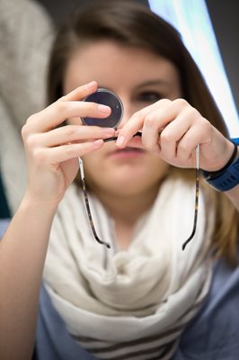 student examining a lens