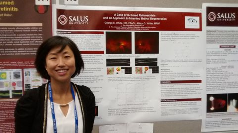 student standing in front of a research poster