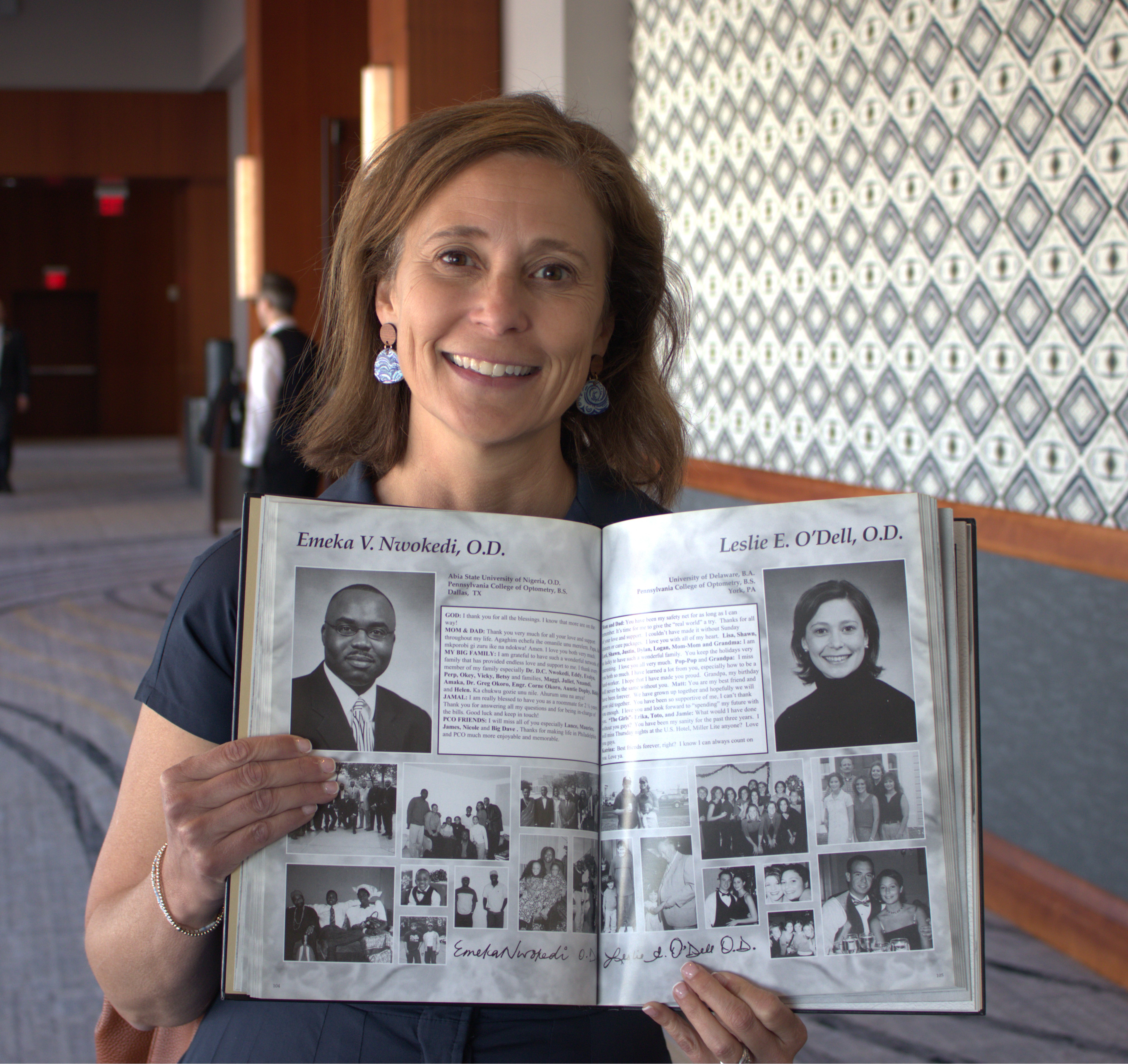 Dr. Leslie O'Dell holding a yearbook picture of herself