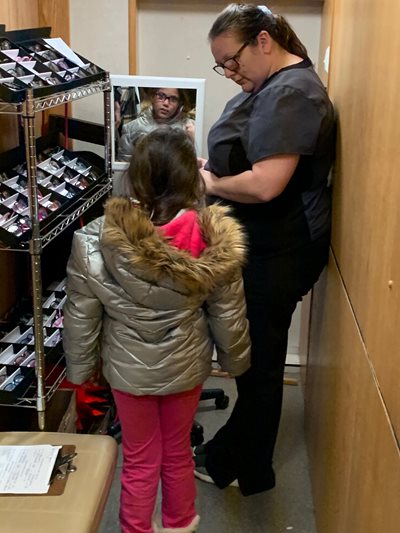 Student trying on glasses on the big red bus
