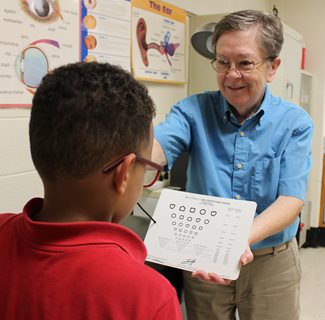 optometrist conducting eye exam on child