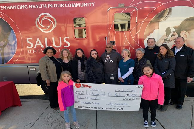 Check presentation in front of the big red bus