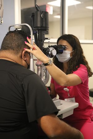 International student performing an eye exam on a patient