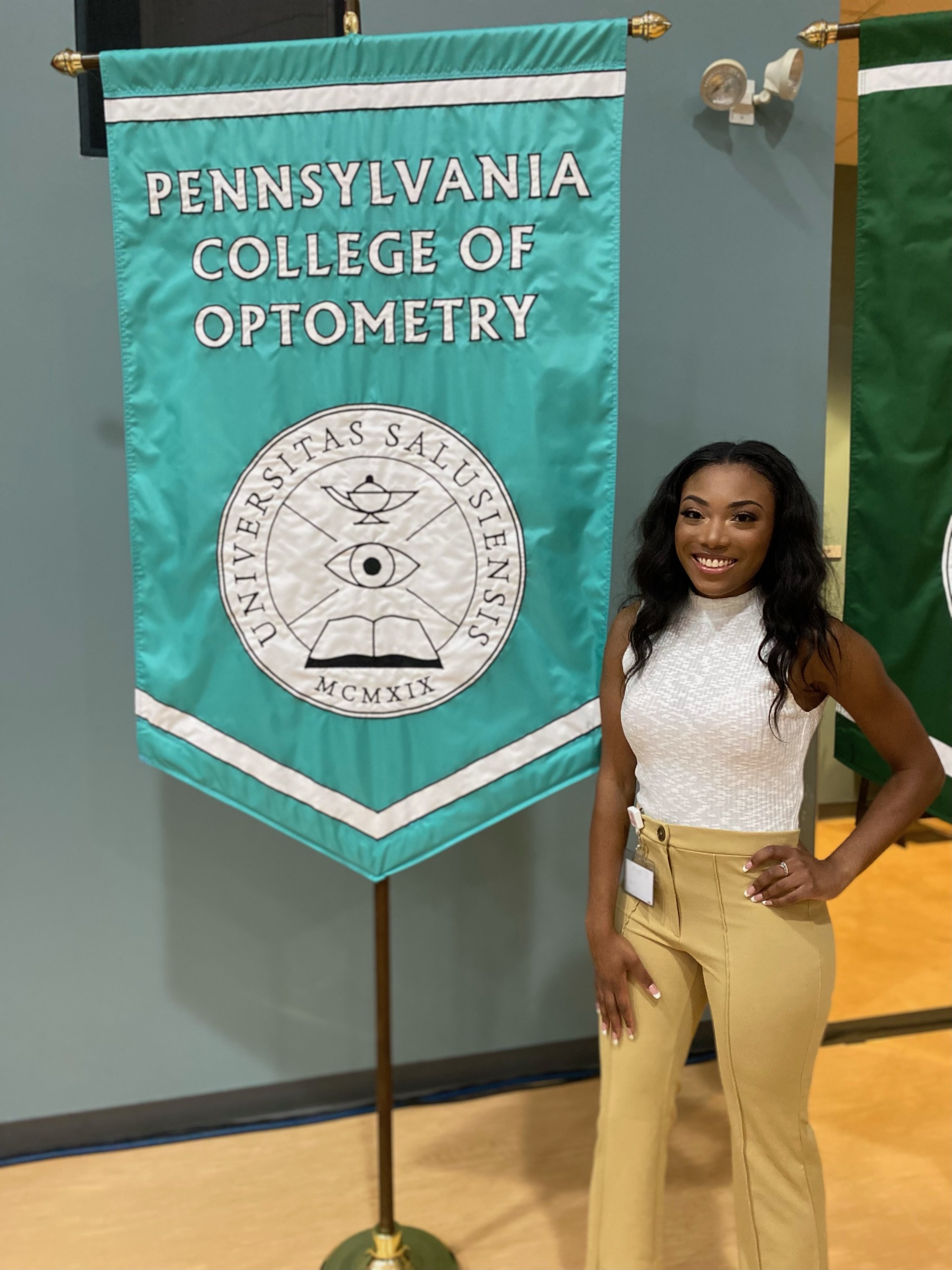 Dr. Williams stands in front of the PCO flag