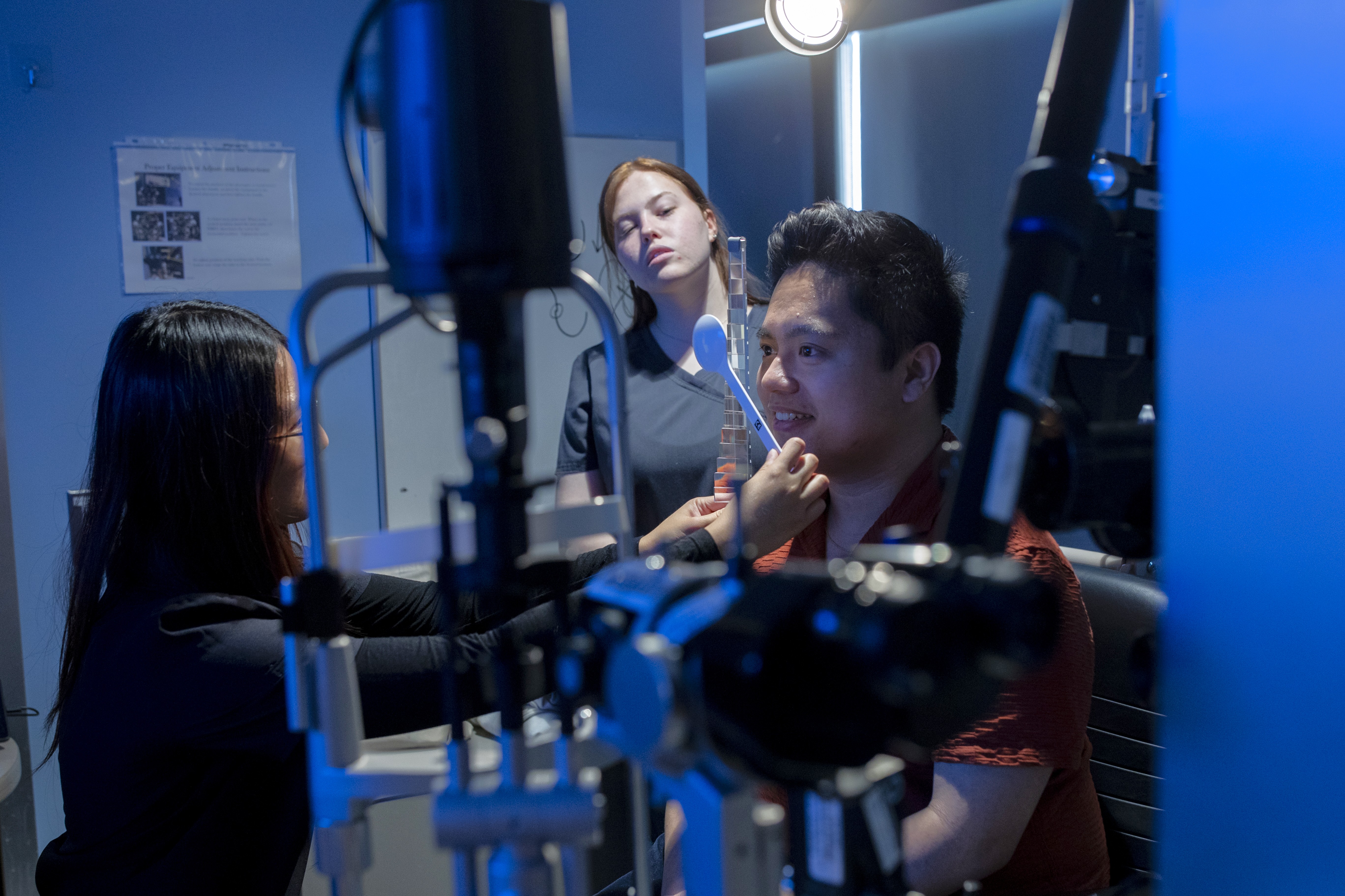 Student in OD lab examining patient while another student looks on