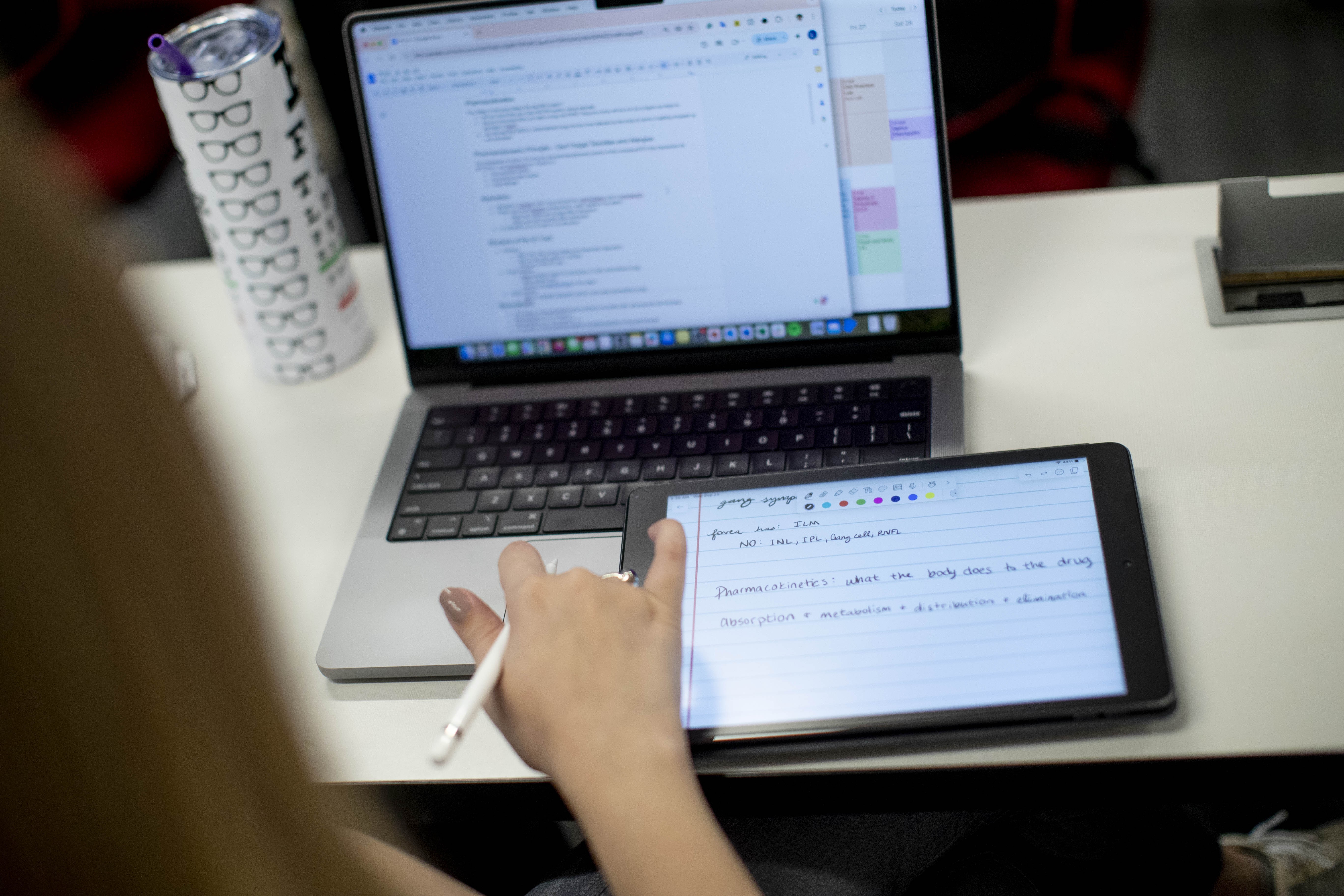 Student with computer taking notes