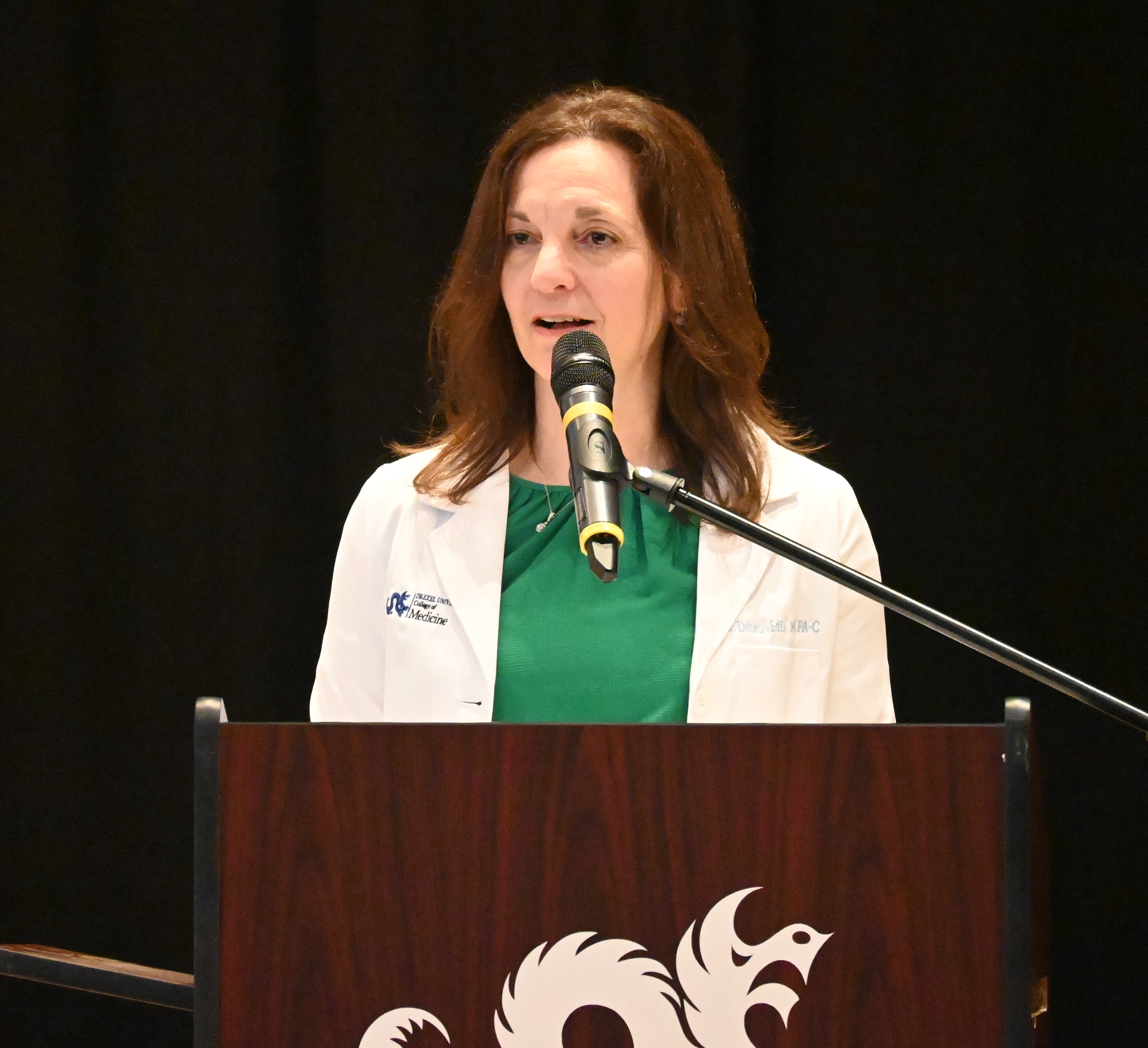 Rachel Ditoro at the podium of white coat