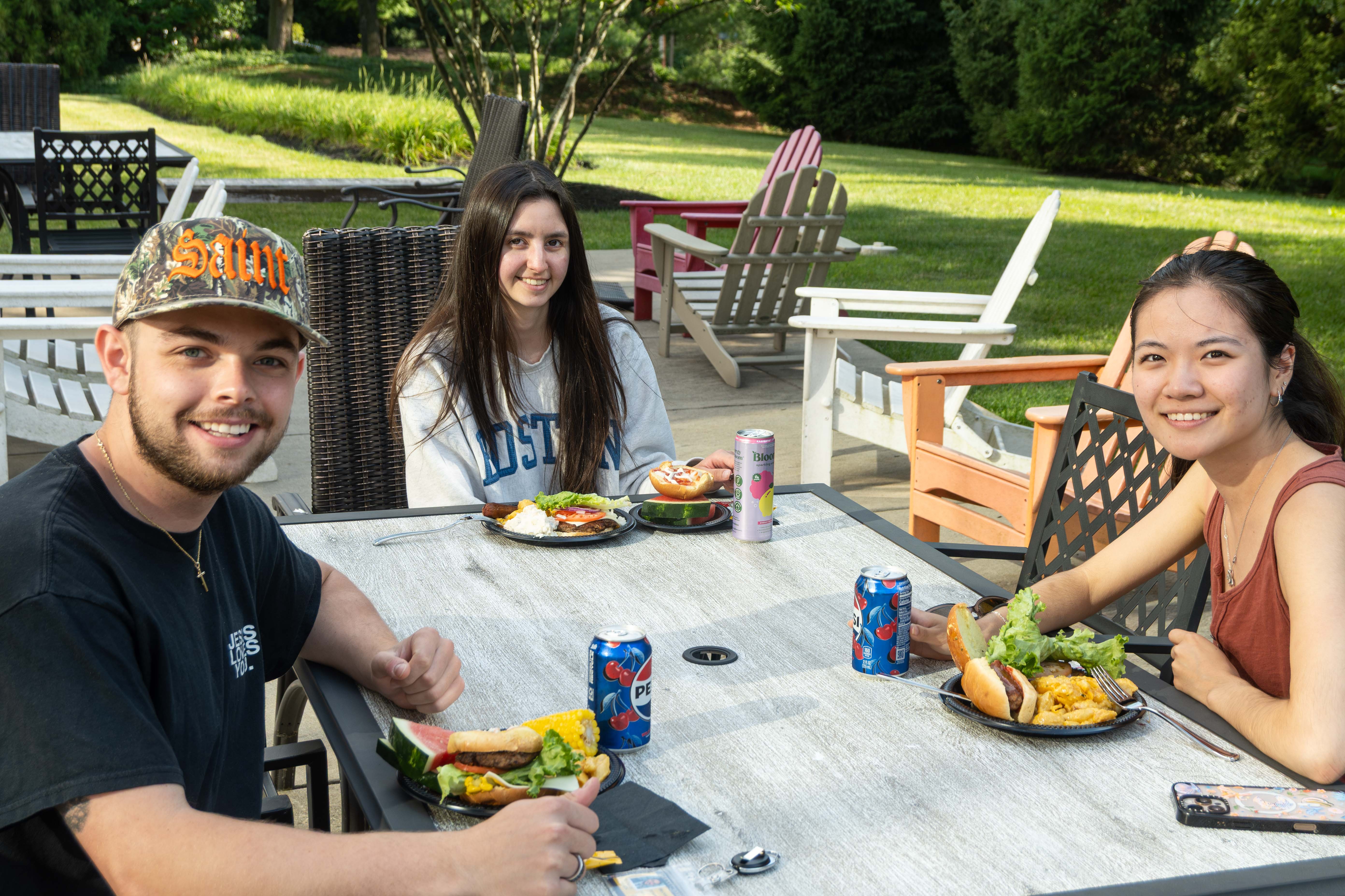 Students sitting outside Hafter enjoying summer barbecue