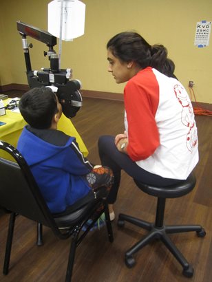 optometrist conducting eye exam on child