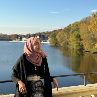 Amal leaning against railing