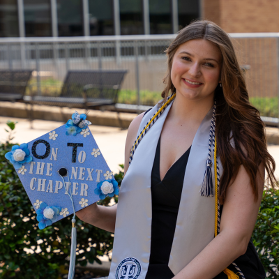 Ashley holding her grad cap