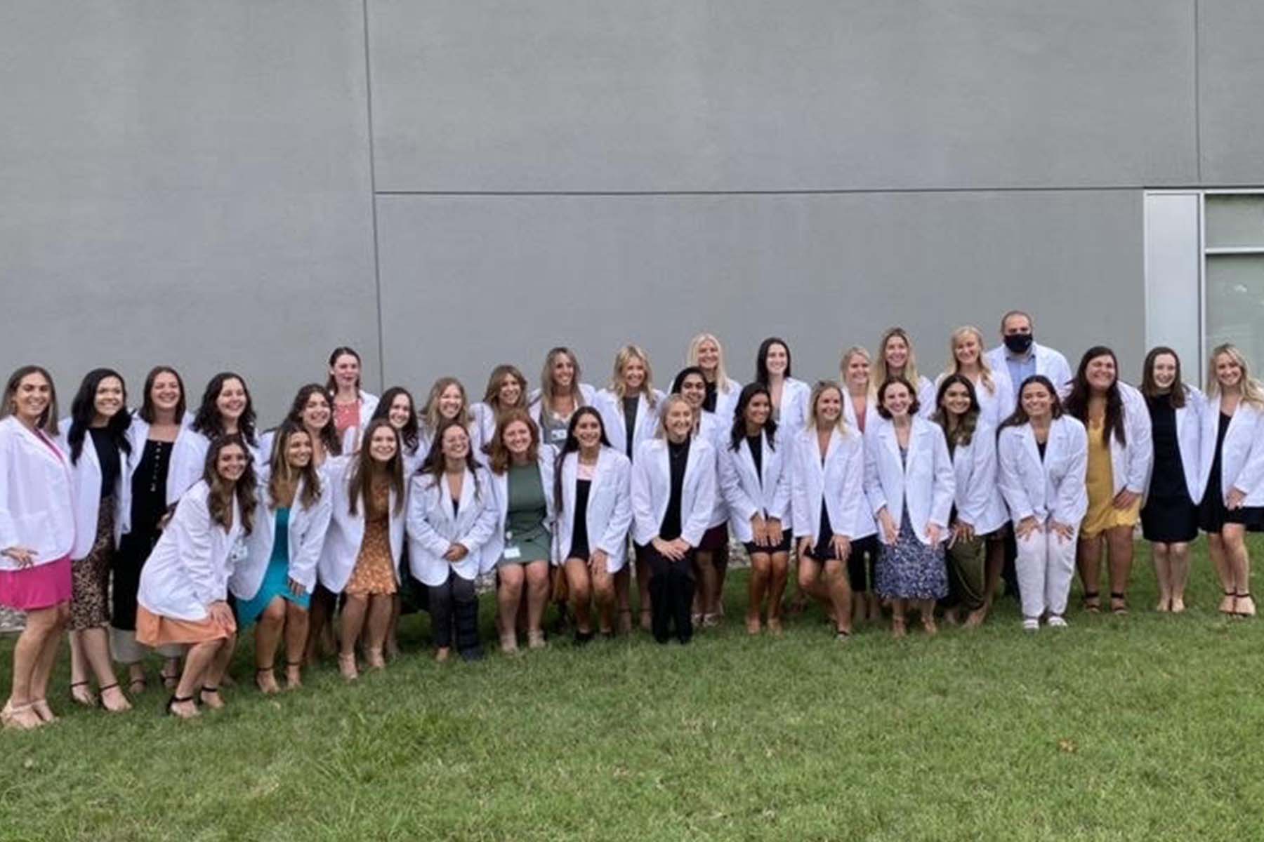 Group photo of Veronica Baez with cohort in white coats