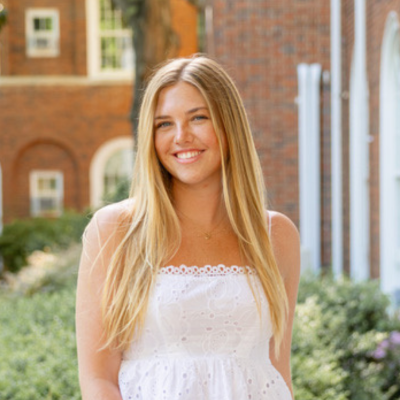 Caroline wearing a white dress