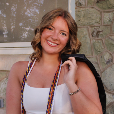 Cassidy wearing a white dress with grad gown