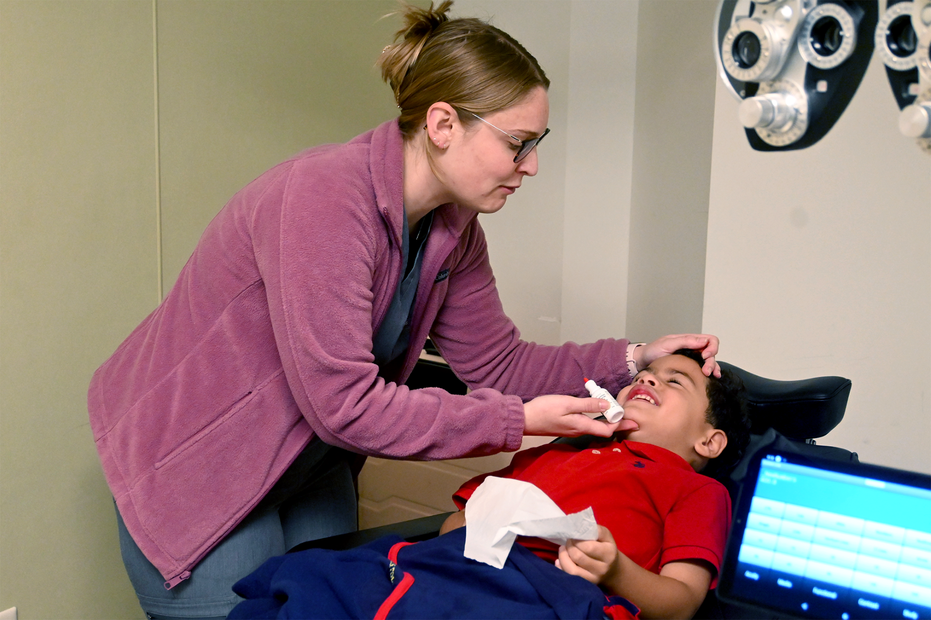 Madison putting eye drops in a child's eyes