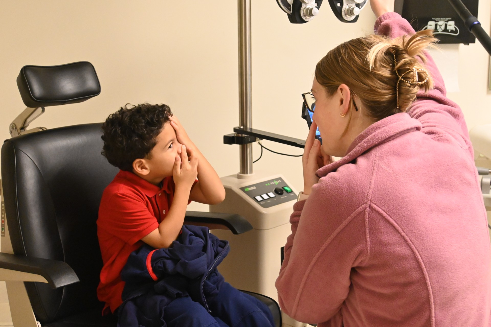 Madison performing eye exam on a child