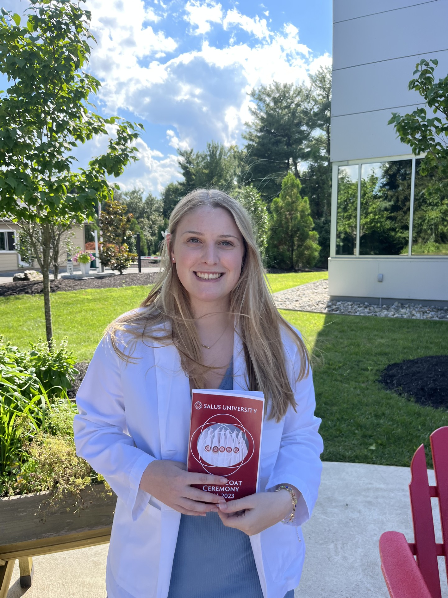 Madison wearing her white coat, holding a program