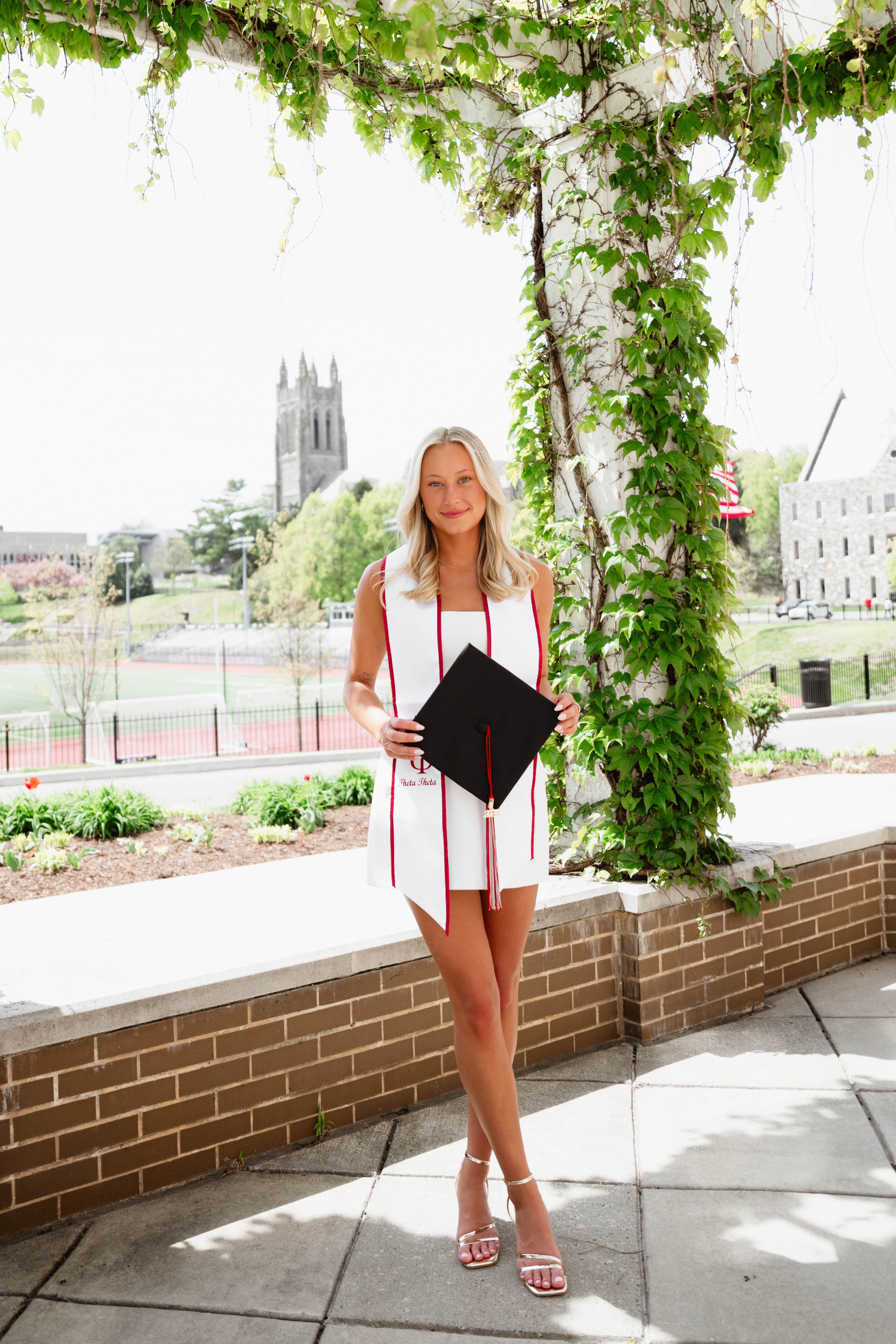 Olivia holding her grad cap
