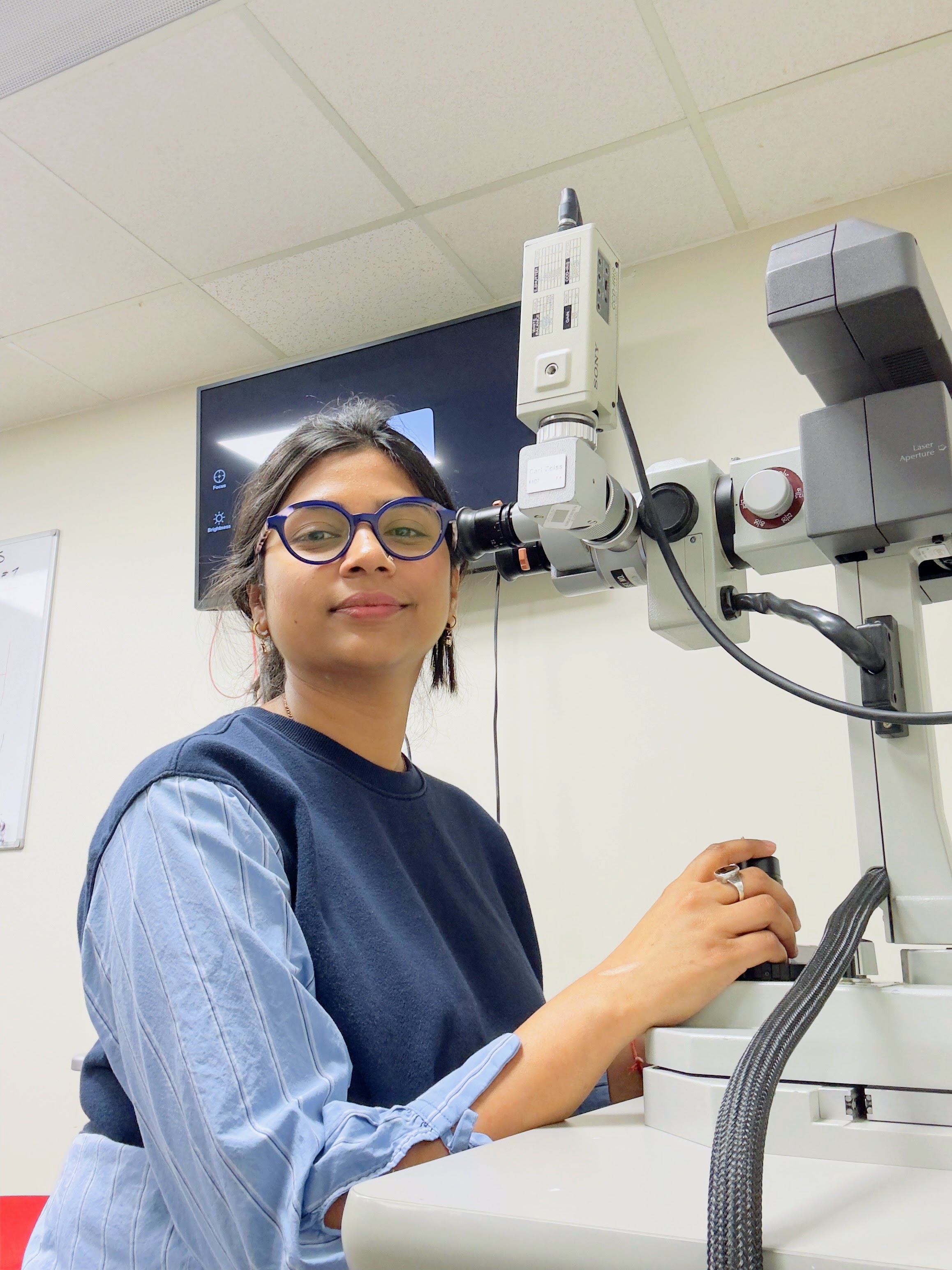 Kiran sitting in front of optometry laser