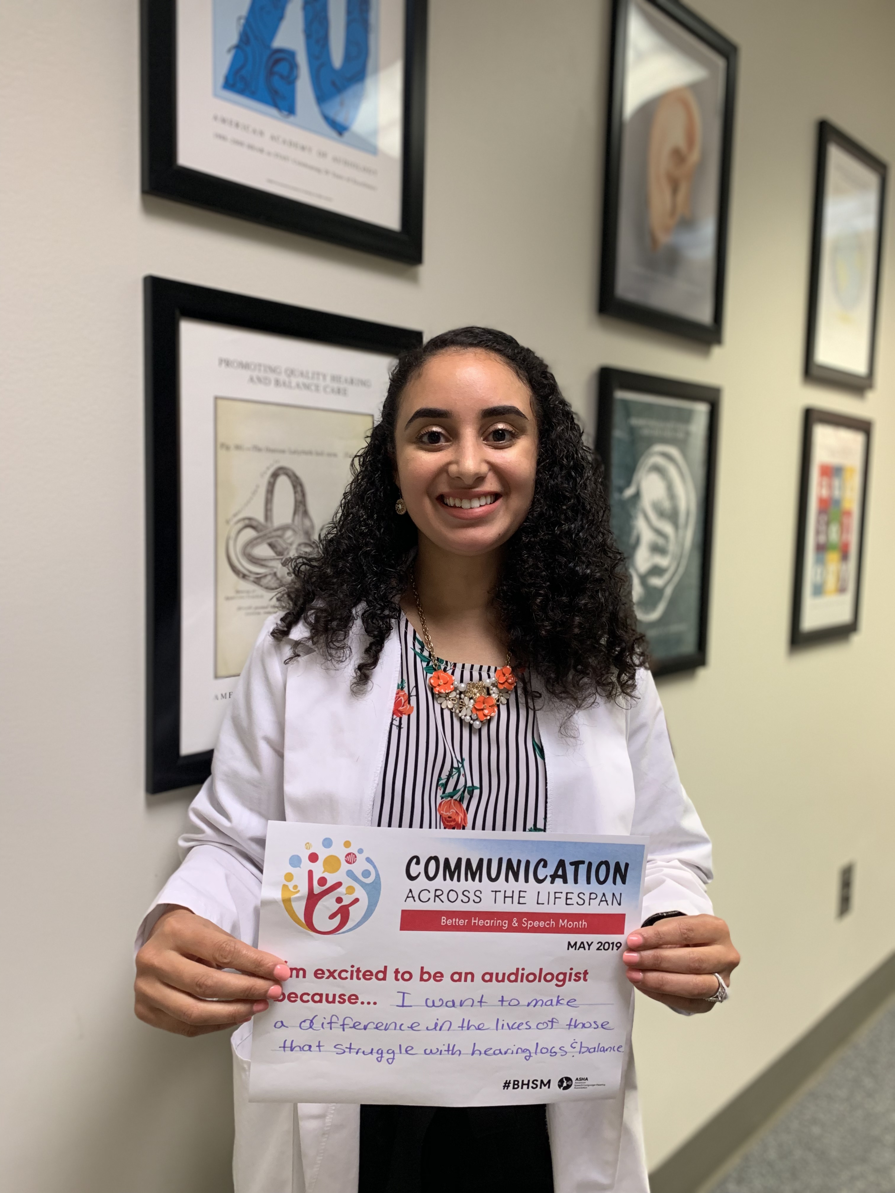 Labib holding a paper that says "Communication across a lifespan"