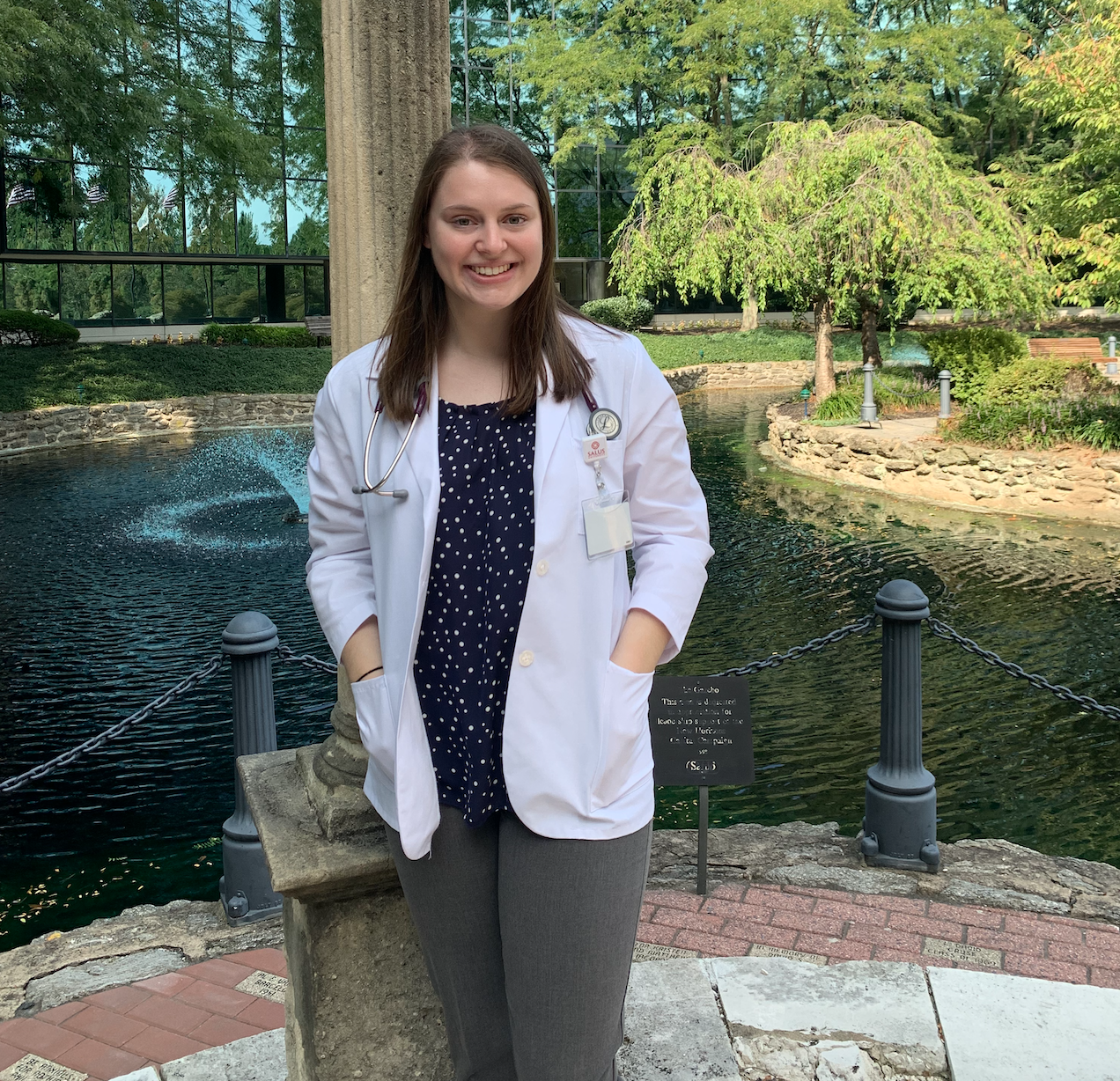 Lauren wearing her white coat at the gazebo on the Elkins Park, Pennsylvania campus