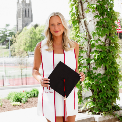 Olivia holding her grad cap