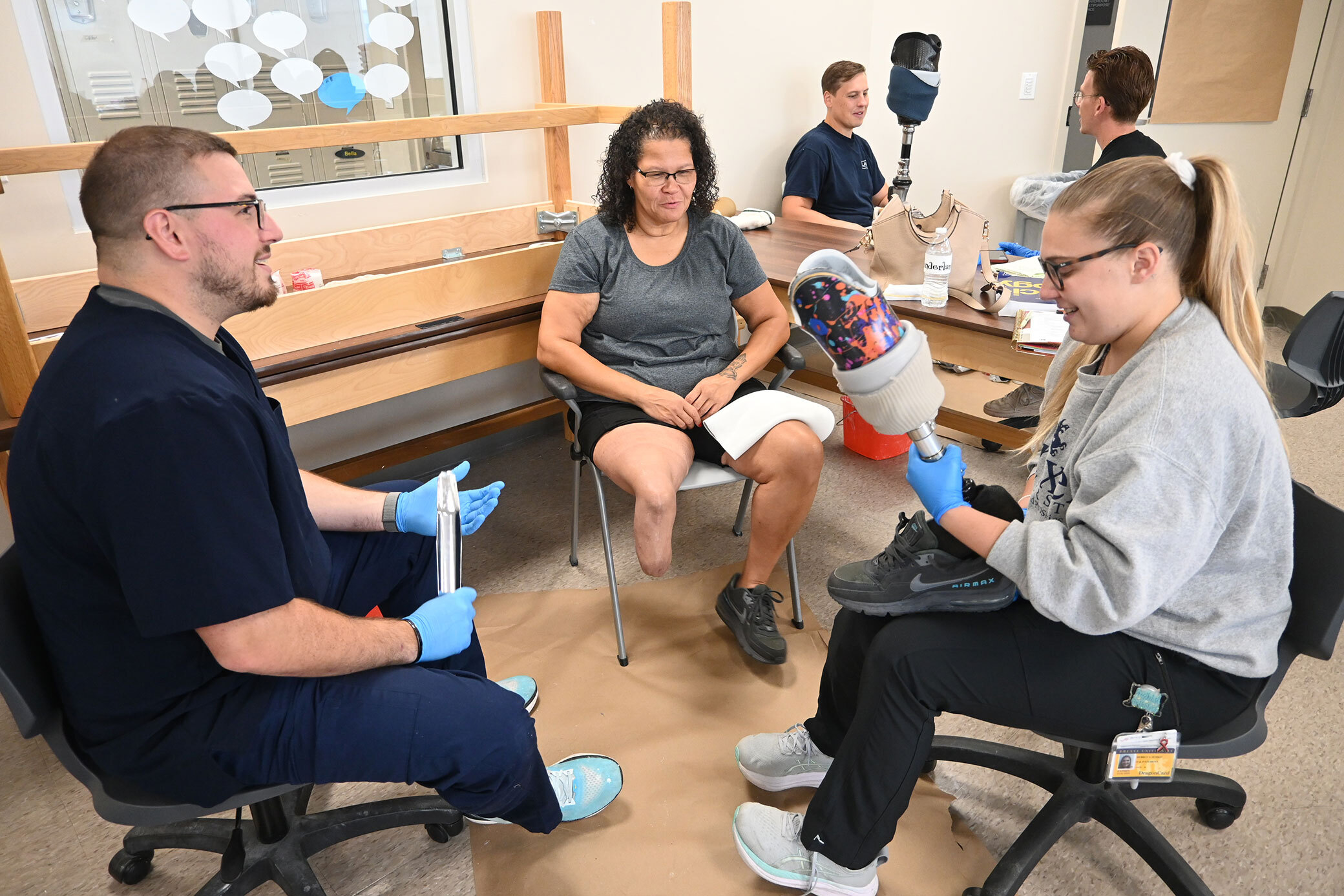 O&P students adjusting prosthetic for patient model